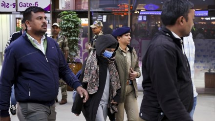Security personnel escort a Gujarat native deported from US after she was brought to the Ahmedabad airport, Thursday, Feb. 6, 2025. A US military plane brought 104 deported Indians to Amritsar on Wednesday. (PTI Photo)
