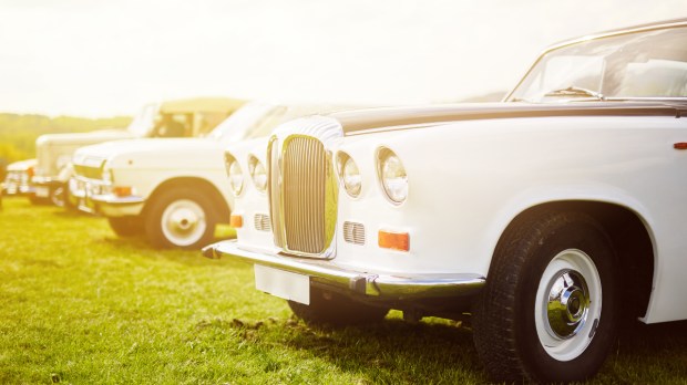 Retro car parked on grass. Film effect filter