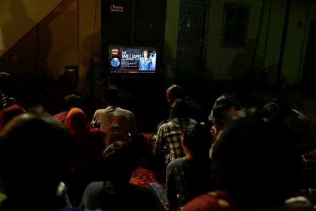 People watch a live telecast of the splashdown of the SpaceX Dragon spacecraft and the safe return of U.S. astronaut Sunita Williams in her native village of Jhulasan, Gujarat. (Image Source: Reuters)