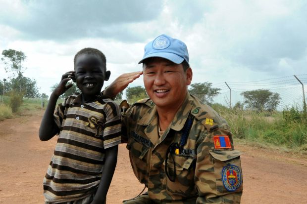 A Mongolian troop with the UN’s mission in South Sudan (UNMISS) smiles with a local boy in Bentiu, Unity State. The Peace Fellows Program supports South Sudan in preparing for their first post-independence elections in 2026 by facilitating civilian support and voter education. (Image: UN Photo)
