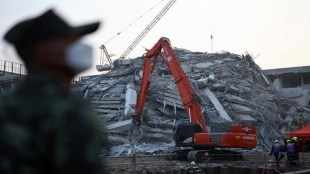 Rescue personnel work with heavy machinery through the rubble of a building that collapsed, following a strong earthquake, in Bangkok, Thailand, March 29, 2025. REUTERS/Athit Perawongmetha