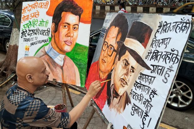 Honouring his uber-patriotic films like Upkar and Shaheed,  a teacher of the Gurukul School of Art paints a portrait of veteran actor-filmmaker Manoj Kumar, who died on Friday, at Lalbaug. (Image: PTI)