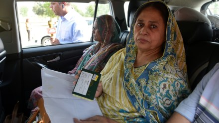 A Pakistani national visiting India displays her passport while waiting to return to her country at the Wagah border checkpoint in Amritsar.