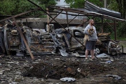 A resident with a dog stands next to cars destroyed in a residential area during a Russian drone strike, amid Russia's attack on Ukraine, in Odesa, Ukraine, May 25 (Photo: Reuters)