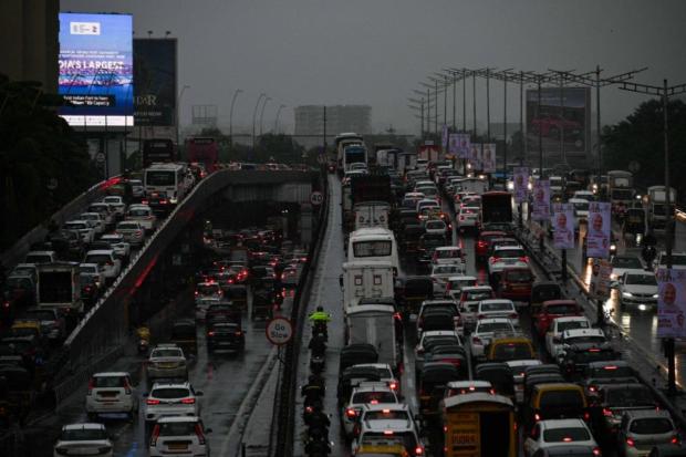 Vehicles move at a slow speed due to heavy rains, at Western Express Highway in Mumbai.