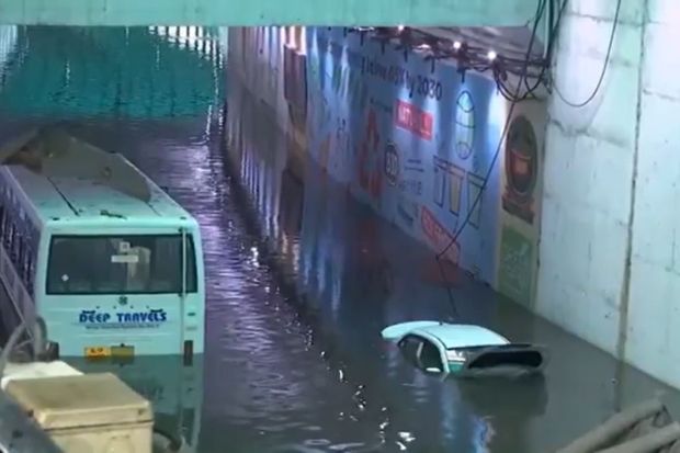 An entire car and a bus were completely submerged under the Delhi Cantonment flyover. Halting major traffic, both vehicles are left completely damaged. (Image: ANI)