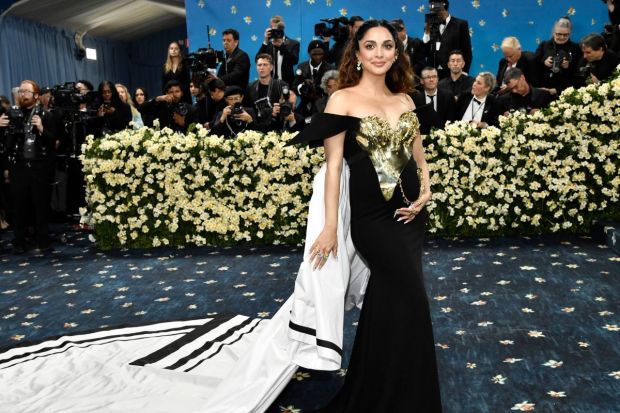 Mum-to-be Kiara Advani flaunted her baby bump in custom Gaurav Gupta couture marking her debut at the Met Gala 2025. Awed audiences with her white trail and metal accents on her black ensemble. (Image: AP)