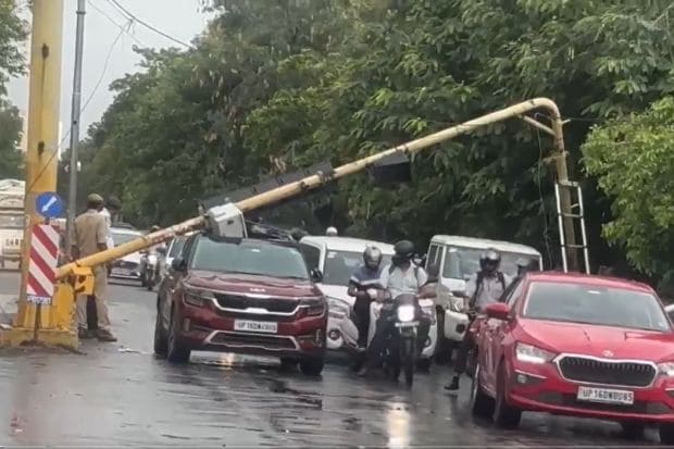 Not far away at a redlight in Noida, a private vehicle suffered great damage and trauma as a redlight tilted and damaged the roof of the car. Stuck underneath, it disrupted traffic for the entire road. (Image: ANI)