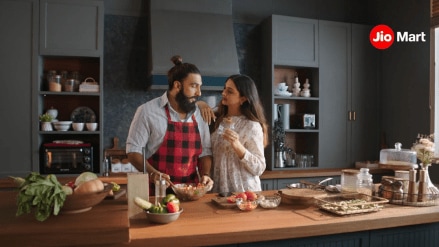 The campaign features four cheeky, slice-of-life films that show the couple navigating relatable kitchen chaos—from “I forgot to buy atta” moments to “late-night ice cream cravings” crises—with JioMart swooping in like a digital superhero
