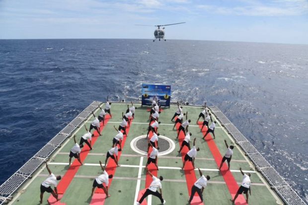  Naval personnel perform Yoga onbard a warship at sea. 