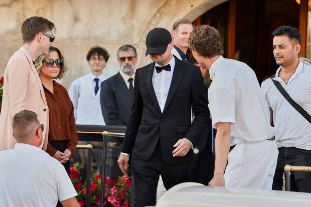 Leonardo DiCaprio hides her face while leaving a hotel ahead of the wedding celebrations (Photo source: AP)