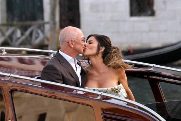 Jeff Bezos and Lauren Sanchez, kiss as they leave a hotel for their pre-wedding reception. (Photo source: AP)