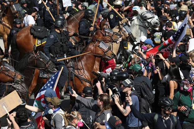 Demonstrators standoff against law enforcement on horseback during a protest Saturday, June 14, 2025, in Los Angeles. (Photo source: AP)