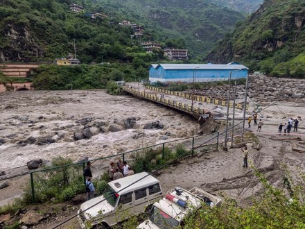People stand near a damaged area at Sainj valley amid flash floods following cloudbursts in Kullu district (Photo: PTI) People stand near a damaged area at Sainj valley amid flash floods following cloudbursts in Kullu district (Photo: PTI)