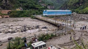People stand near a damaged area at Sainj valley amid flash floods following cloudbursts in Kullu district (Photo: PTI)