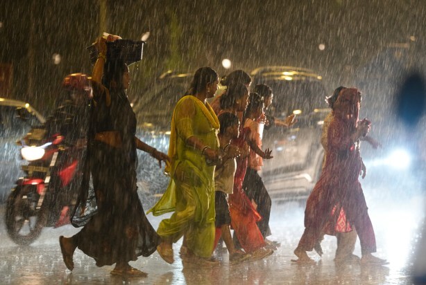 Commuters cross a road amid rainfall in New Delhi. The monsoon covered Delhi two days after the normal date and advanced over the rest of the country ahead of schedule, according to the India Meteorological Department. (PTI Photo)