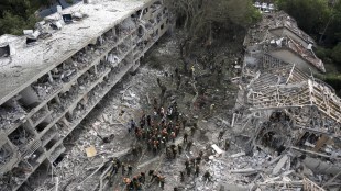 Rescue workers and firefighters survey the site of a direct missile strike launched from Iran in Tel Aviv (Photo: AP)