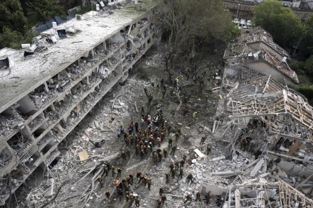 Rescue workers and firefighters survey the site of a direct missile strike launched from Iran in Tel Aviv (Photo: AP)