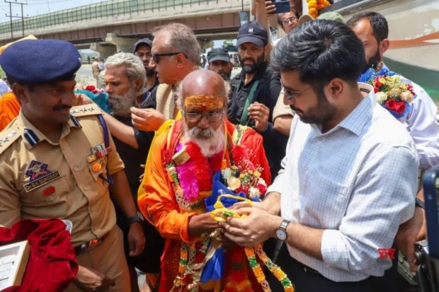 A district administration official welcomes the first group of Amarnath Yatra pilgrims at the Pantha Chowk bypass in Srinagar on Wednesday, July 2. (Image Source: IANS)