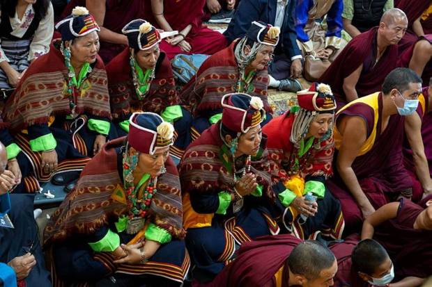 Devotees watch Tibetan spiritual leader the Dalai Lama on a television screen during the vent. (Photo source: AP)