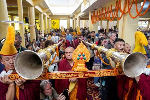 Members of Tibetan cultural groups blow long horns during the long life prayer ceremony for the Tibetan spiritual leader, the Dalai Lama. (Photo source: PTI)