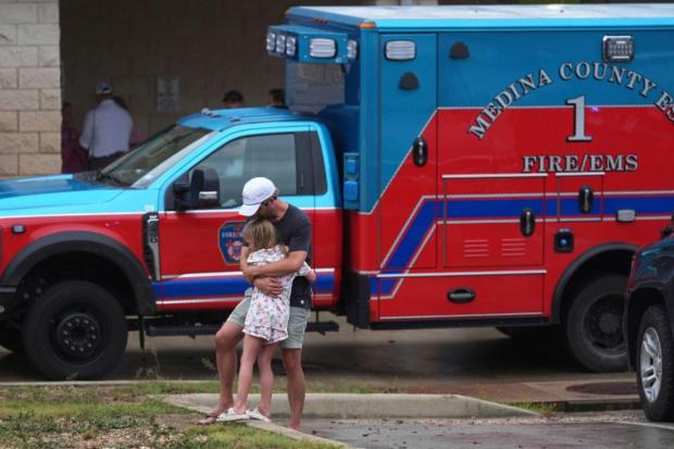 People are reunited at a reunification center after flash flooding hit the area.