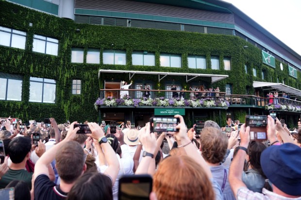 Jannik Sinner holds the winner’s trophy from the Centre Court balcony after defeating Carlos Alcaraz to win the men’s singles final at Wimbledon. (Photo: AP)