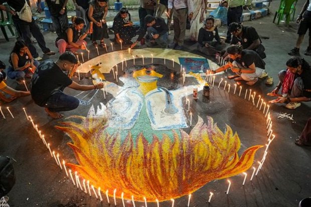 Protesters, including doctors, held a night-long vigil in Kolkata's Shyambazar, lighting candles and surrounding a graffiti to mark the one-year anniversary of the rape and murder of a trainee doctor at RG Kar Medical College and Hospital.(Image Source: PTI)