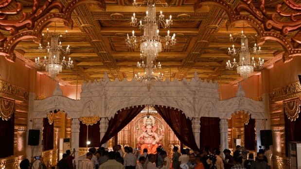 Visitors take photos of Andheri-cha Raja Ganesh idol as its first look is inaugurated today, at Andheri west in Mumbai on 26 August 2025. The pandal theme is inspired from Gujarat's Sarangpur Shree Kashtabhanjan Dev Hanumanji Temple (Express Photo)