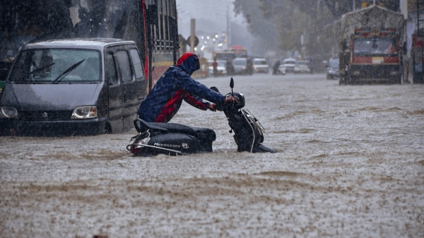 Mumbai residents braved knee-deep water as continuous rainfall turned city streets into mini streams in multiple suburbs, including Andheri and Lokhandwala. (Photo Source: PTI)