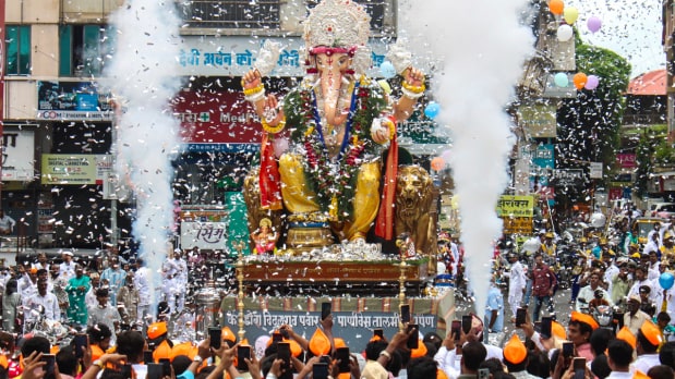 People celebrate as they carry an idol of Lord Ganesh on ‘Ganesh Chaturthi’ festival, in Solapur, Maharashtra on Wednesday, Aug. 27 (Photo Source: PTI)