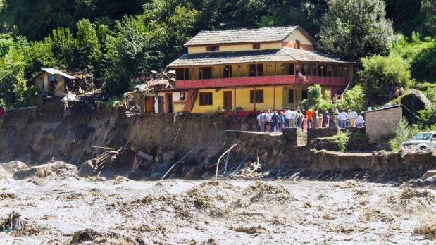 People gather near a house to check for damage and take stock of the disruption caused by the overflowing  Beas river in the Kullu district of Himachal Pradesh. (Photo Source: PTI)