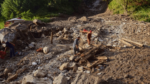 Villagers collect wood and other useful items from the debris of damaged houses at the incident site of a cloudburst that triggered a flash flood, in Naryan Behak village near Muzaffarabad in Pakistan. (Photo Source: Associated Press)