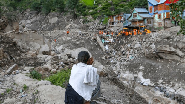 A local woman sits by a damaged area as a search and rescue operation is underway after the recent flash flood triggered by a cloudburst, at Chisoti village, in Kishtwar district, Jammu and Kashmir, Saturday, Aug. 16, 2025 (Photo Source: PTI)