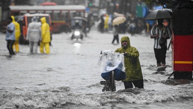  Vehicles and pedestrians wade through waterlogged Swami Vivekananda Road at Andheri West in Mumbai on 19 August 2025. (Photo Source: Indian Express)