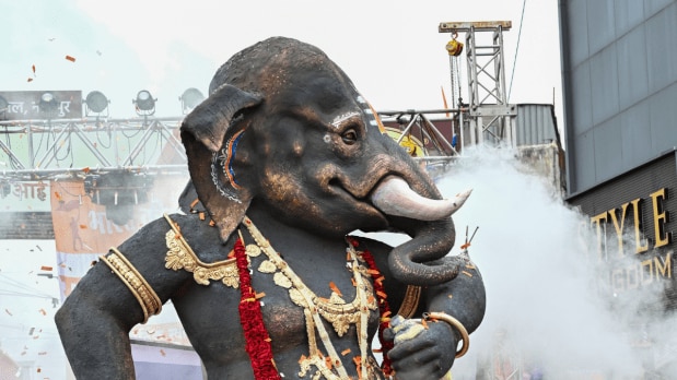  People in Hyderabad celebrate the festival by gathering and dancing around a tall statue of Ganesha built with natural materials and colours. (Photo Source: PTI)