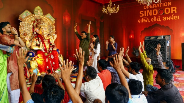 People offer prayers to Lord Ganesh at a 'pandal' on ‘Ganesh Chaturthi’ festival, in Ahmedabad on Wednesday, Aug. 27, 2025. The temple also had slogans displaying pride in Operation Sindoor’s success on the walls. (Photo Source: PTI)