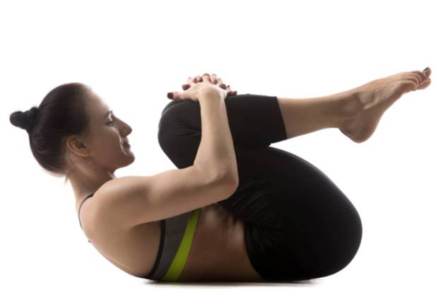 Apanasana (Knee to chest pose)- It is a gentle stretch in which abdomen is compressed and helps in releasing the trapped gas. Rocking from side to side can further help in digestion. (Photo source: Canva)