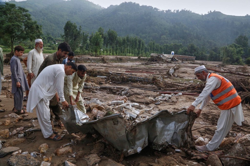 Local residents search through an area covered with mud and debris (AP Photo) Local residents search through an area covered with mud and debris (AP Photo)