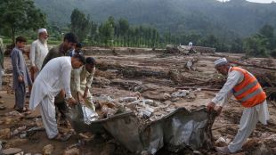 Local residents search through an area covered with mud and debris (AP Photo)