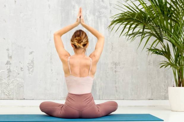 Seated heart opener-In this yoga posture, the throat, belly and chest is stretched to relief from cramping and bloating. (Photo source: Canva)