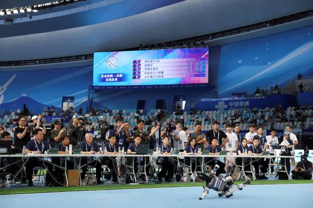 Judges are evaluating the performance of a humanoid robot as it competes in the gymnastics final round. (Photo source: Reuters)