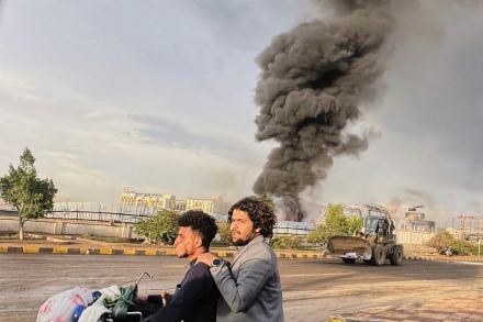 People ride a motorbike as smoke billows following Israeli airstrikes on multiple areas including a power planet and a gas station in Sanaa (Photo: AP)
