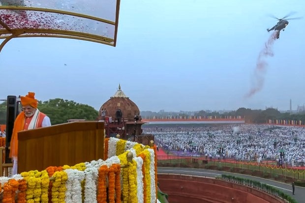 Prime Minister Narendra Modi stands for the national anthem after hoisting the national flag during Independence Day celebration at the Red Fort in New Delhi. (Image source: PTI)