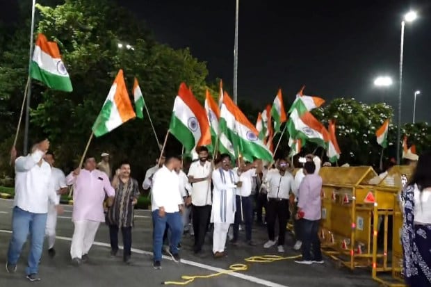 People wave the Indian national flags as they wait to welcome Astronaut Shubhanshu Shukla ahead of his arrival at the Indira Gandhi International (IGI) Airport in New Delhi. Shukla is returning to India following his landmark visit to the International Space Station (ISS) as part of the Axiom-4 mission. (Image source: PTI)