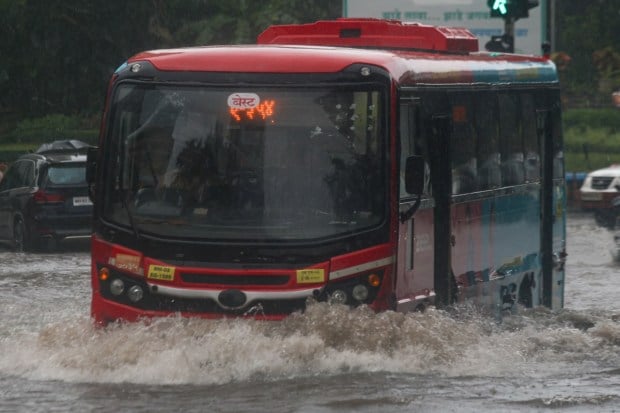 The waterlogged roads left thousands of daily commuters stranded, forcing many to wade through waist-deep water or wait for hours. This highlighted once again how rainfall brings the city’s overburdened transport system to a halt. (Express Photo)