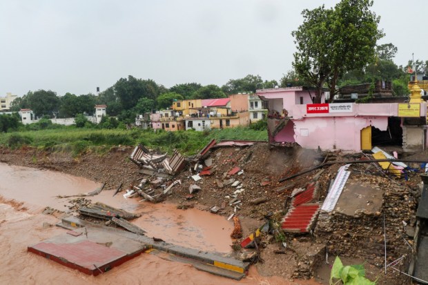 Debris of a house partially collapsed as the Tawi river flows in spate due to heavy rainfall. (Image source: PTI)