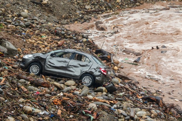A car lies damaged amidst debris after a portion of a bridge was washed away amid rise in the Tawi river water level due to heavy rainfall. (Image source: PTI)