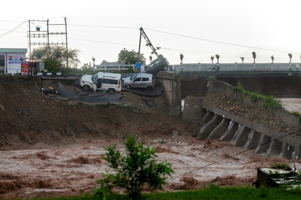 Vehicles stuck as a portion of the Fourth Tawi Bridge was damaged after relentless rainfall at Bhagwati Nagar. (Image source: PTI)