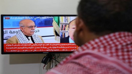 A man watches the news on TV, displaying footage of Ahmed al-Rahawi, the prime minister of the Houthi-controlled government, who was killed, along with others, in Thursday's Israeli strikes on the capital, in Sanaa, Yemen, Saturday, Aug. 30, 2025. (AP Photo/Osamah Abdulrahman)